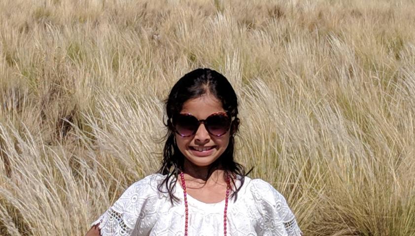 Rhea standing in front of a field