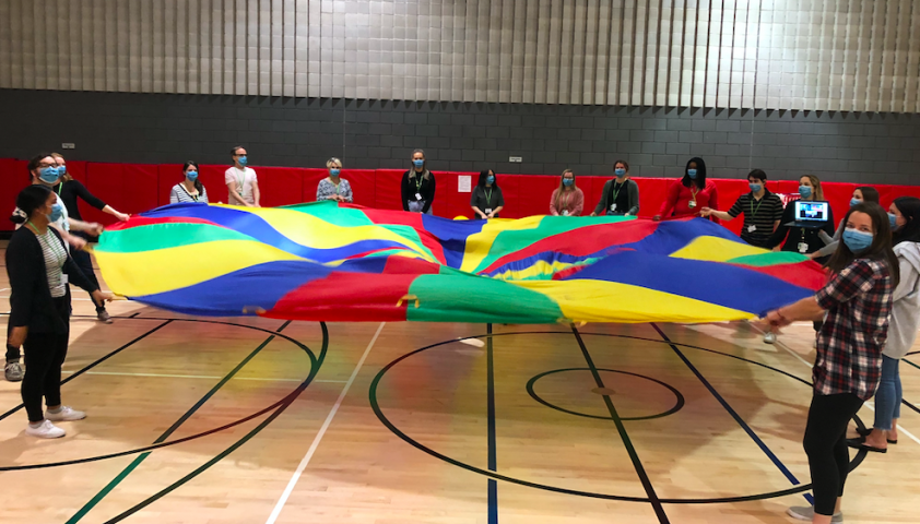 The team playing with a parachute.