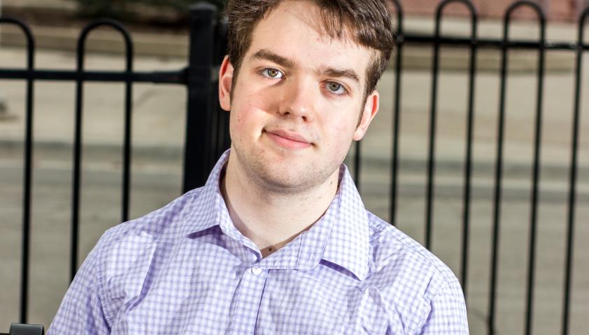 Spencer looking at the camera dressed in a collared shirt. 