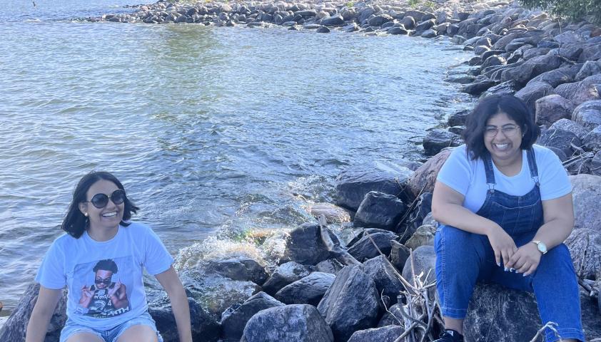 Swetlana and friend sitting on a rocky beach.