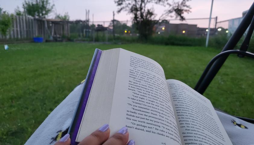 An open book, reading in the grass. 