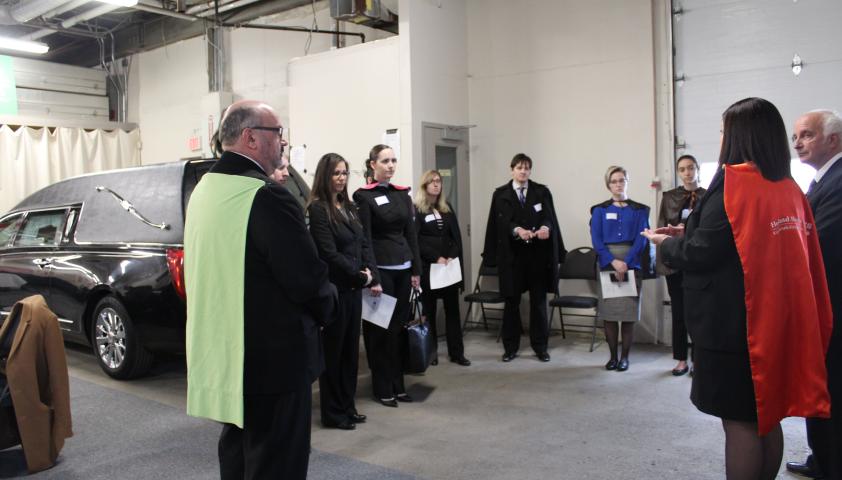 Group of people standing in a circle wearing capes.