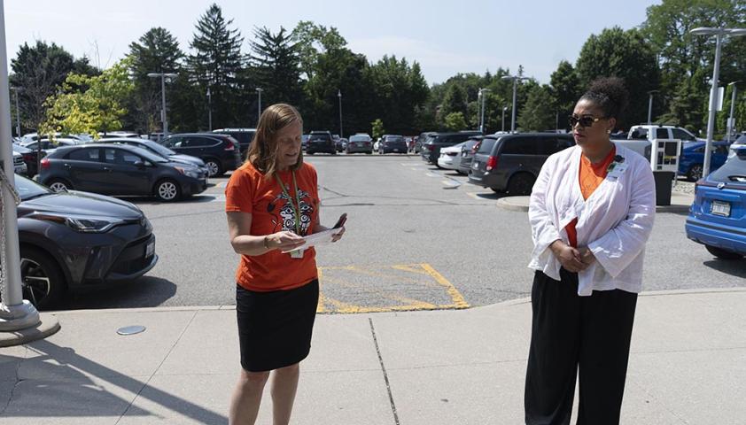 2 people standing in a car parking lot