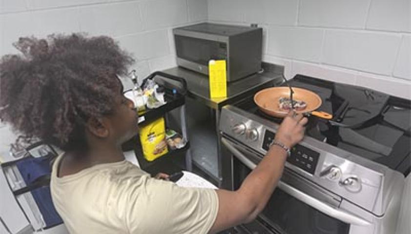 A teenager is cooking in a kitchen