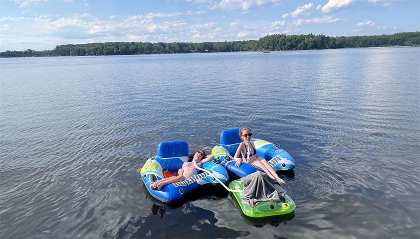 Two teenagers are enjoying floating on the water in a lake