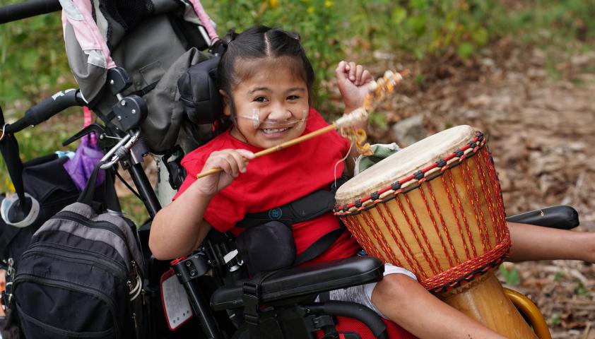 child playing with drum in Spiral Garden