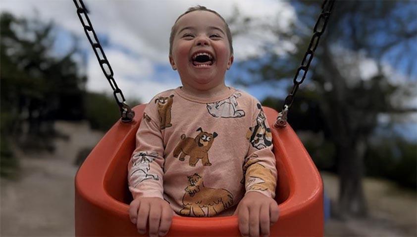A boy playing swing in a park