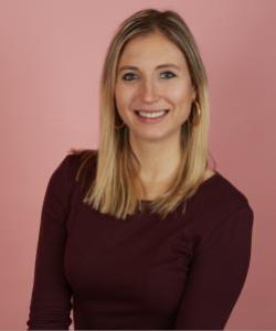 Photo of of a woman with long blonde hair wearing a burgundy shirt