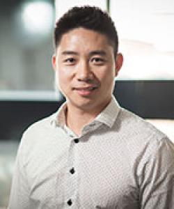 Man in grey shirt with dark brown hair