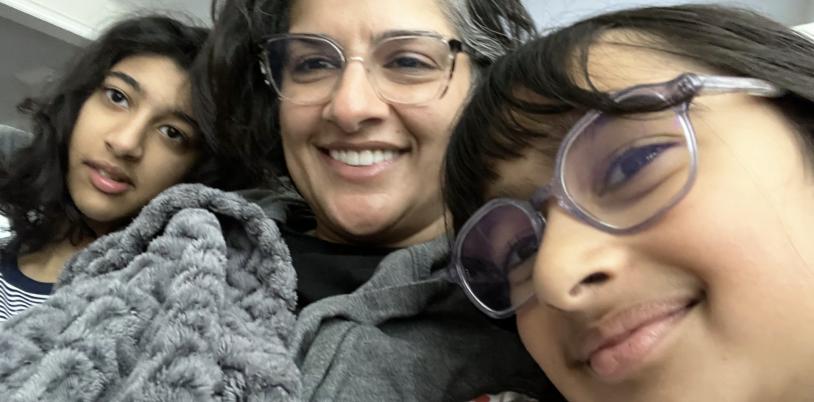 Girl with glasses and woman and teen girl under blankets