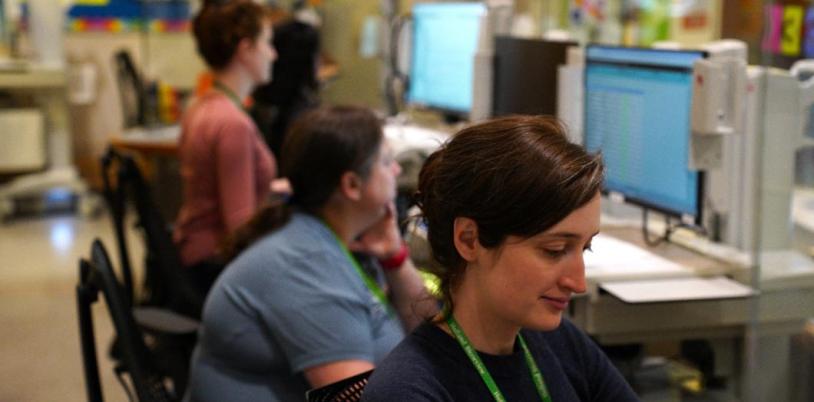 A nurse works alongside colleagues at a nursing station in the inpatient unit at Holland Bloorview Kids Rehabilitation Hospital.