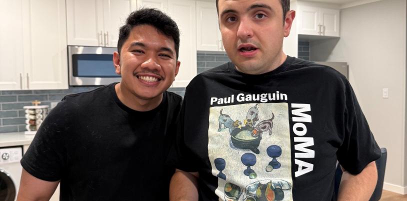 Two young men with kitchen behind them