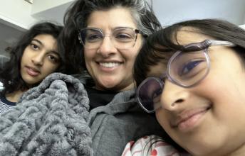 Girl with glasses and woman and teen girl under blankets