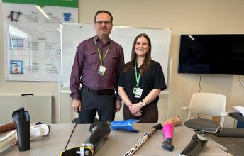 A man and a woman standing behind some tools for disabilities