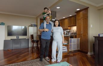 Man with young son on shoulders beside woman