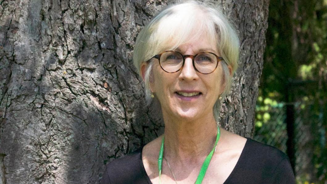 Woman stands in front of tree