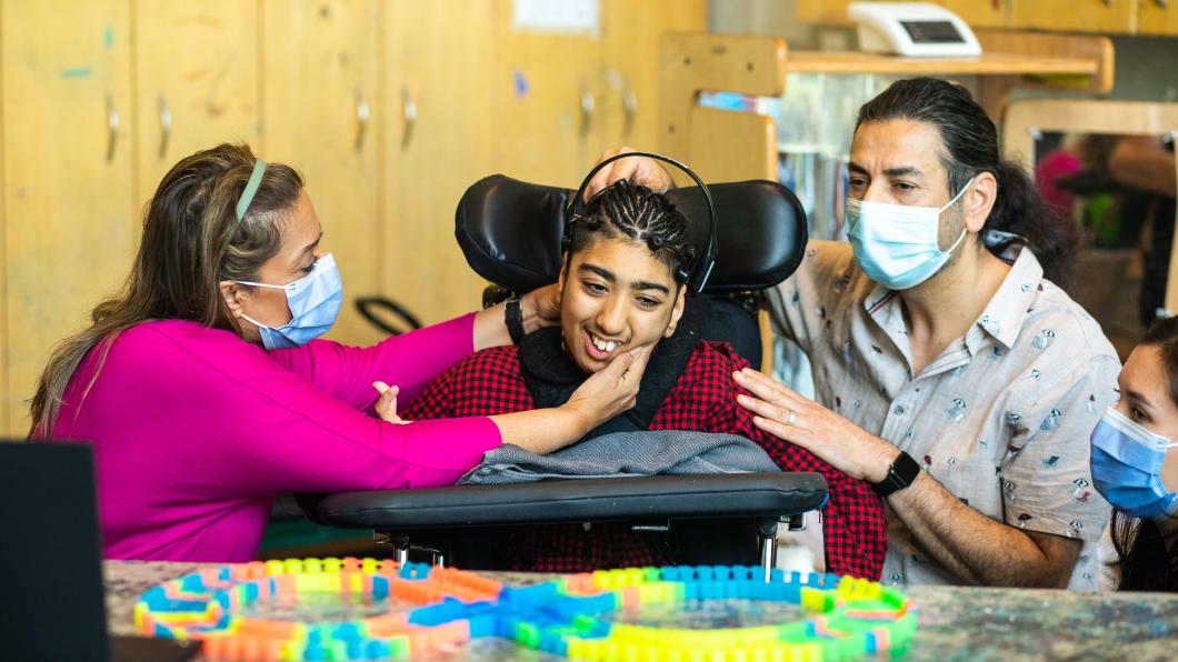 Hospital staffs setting up a headset machine on a child's head