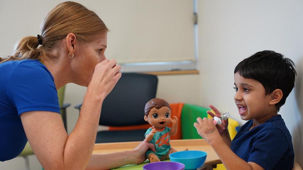 A clinician is talking with a young patient