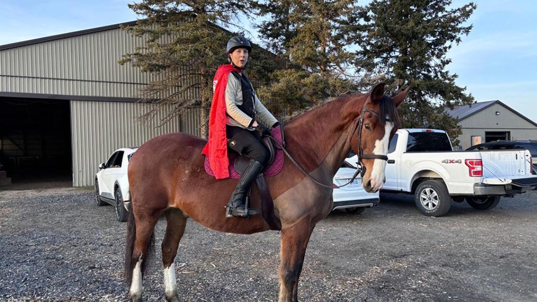 Woman in red cape on horse