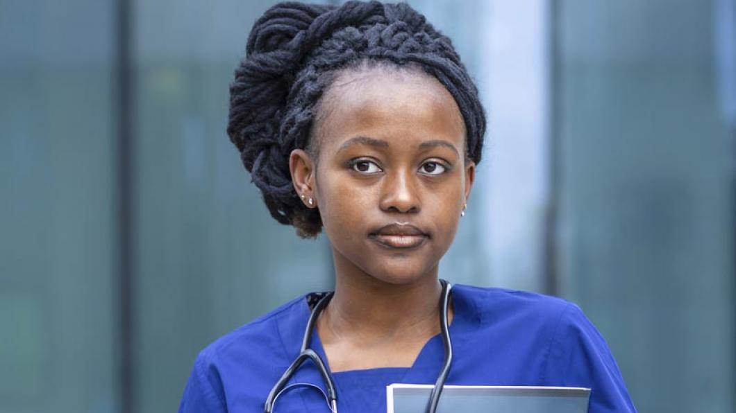 Medical student with black hair up in braids and stethoscope around neck