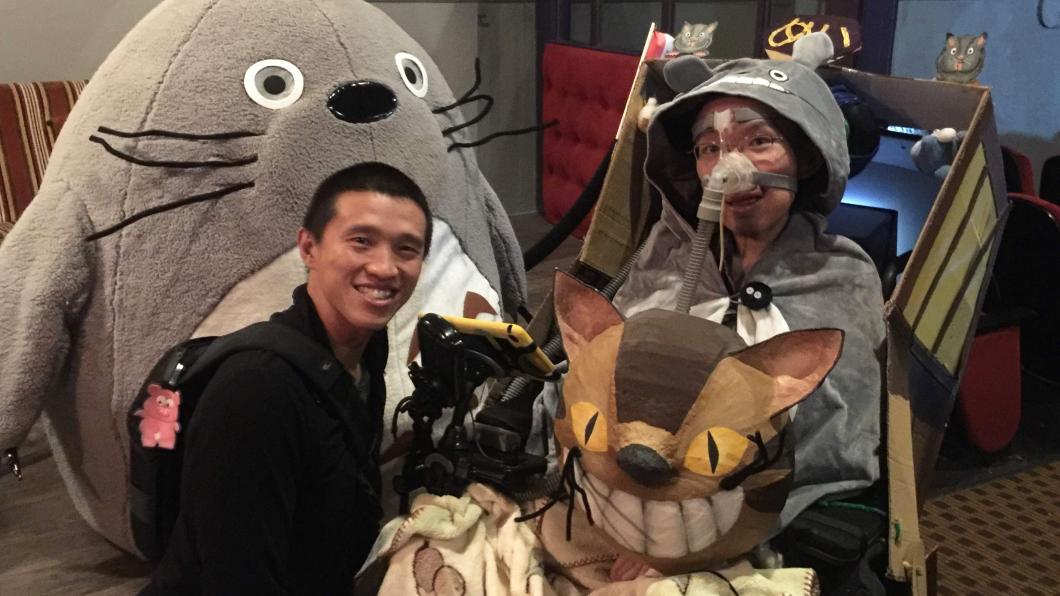 Man wearing Totoro costume beside another man with large plush character