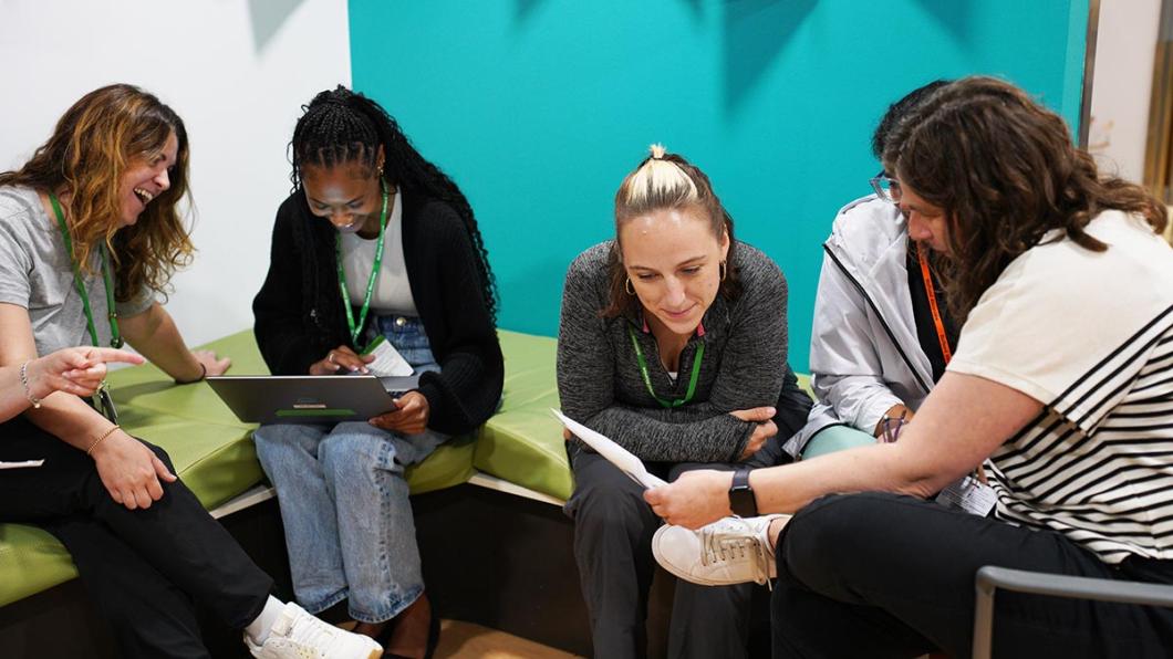 Four adults in an indoor setting, in a meeting