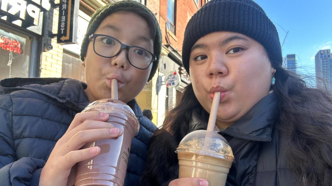 A woman and a boy slurp frothy drinks