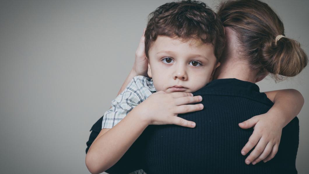 Boy being held in a woman's arms