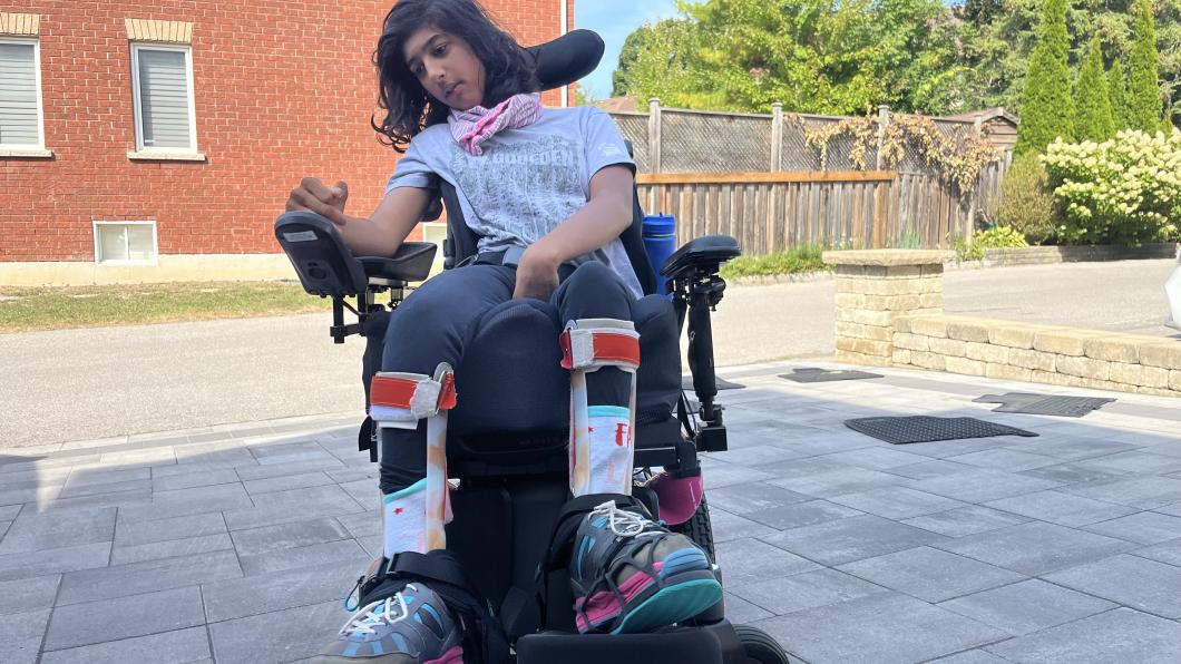 Teen girl uses power wheelchair outside