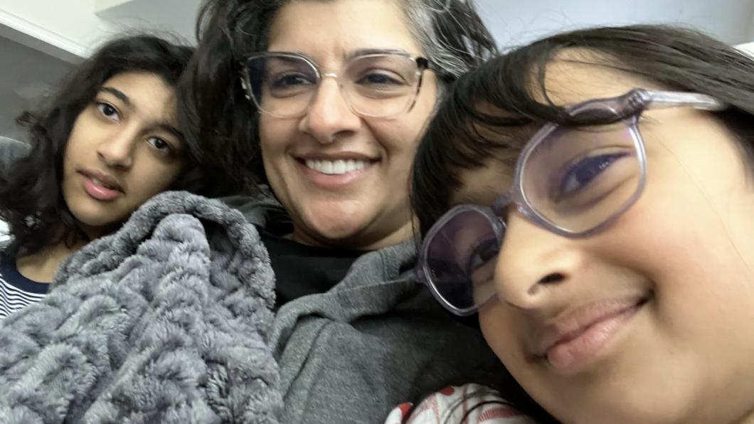 Girl with glasses and woman and teen girl under blankets