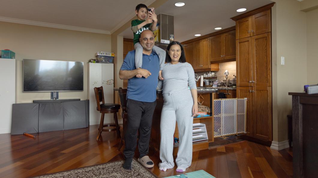 Man with young son on shoulders beside woman