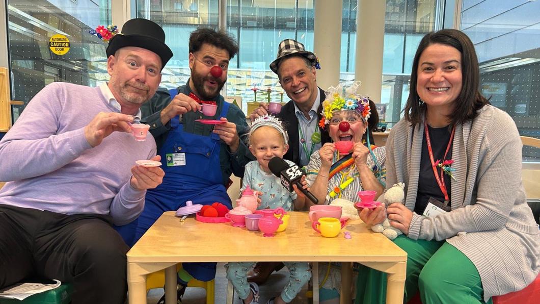 Some adults playing with a kid in a playroom