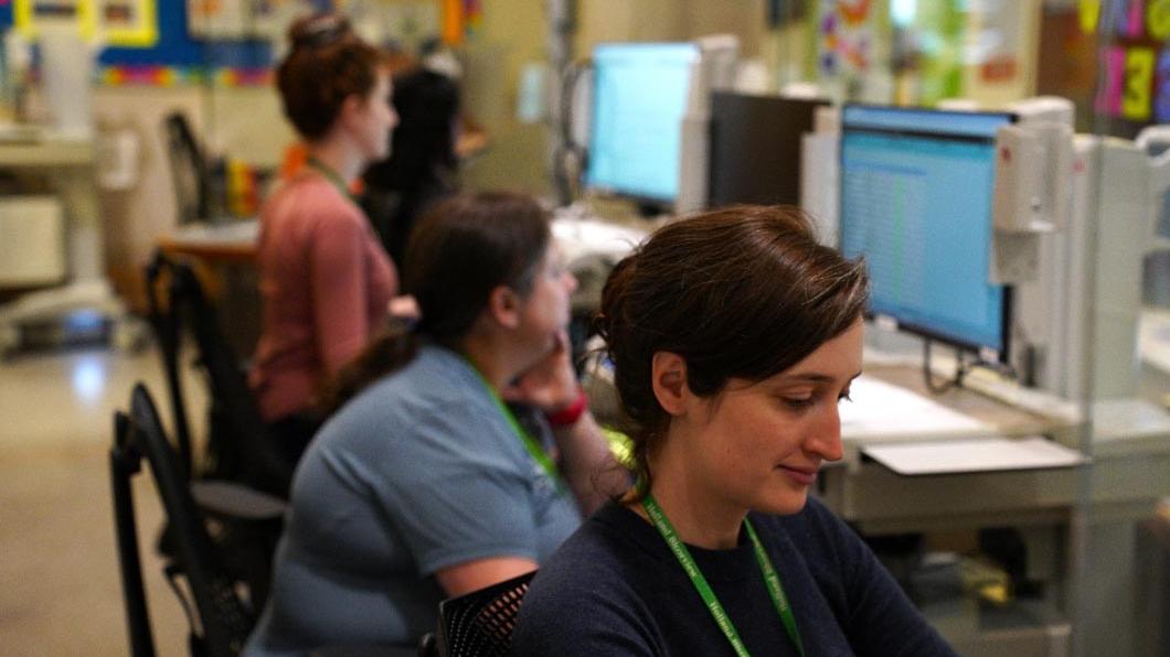 A nurse works alongside colleagues at a nursing station in the inpatient unit at Holland Bloorview Kids Rehabilitation Hospital.