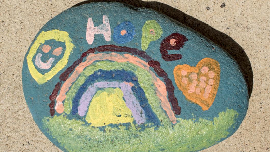 Image of a painted rock with the word hope and a rainbow