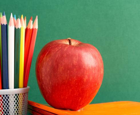 Pencil and apple on a school chalkboard