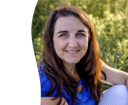 Image of Tracy Shepherd wearing a blue shirt in a grassy field next to the Holland Bloorview logo on white