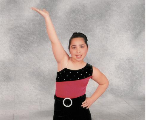 Sam as a kid posing in her dance costume. 