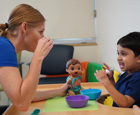 A clinician is talking with a young patient