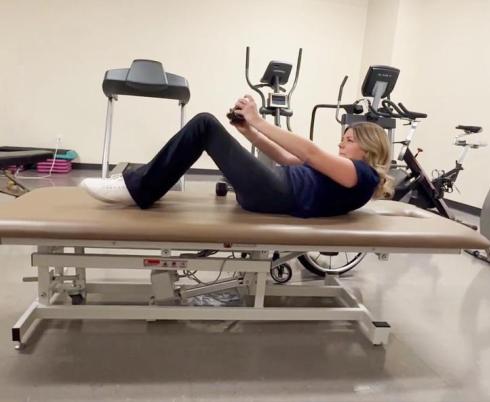 A person doing workout on a gym bed