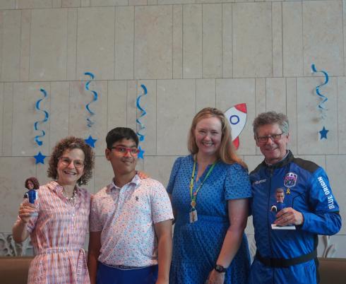 A group of adults and a kid smile