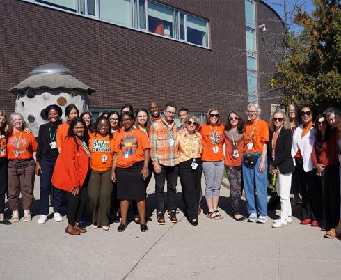 Group of people in an outdoor setting wearing orange