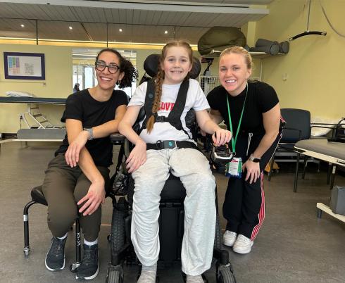 Two adults with a child on a wheelchair