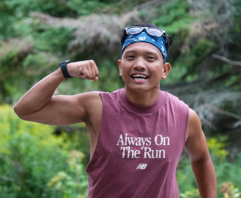 A man runs and flexes his bicep