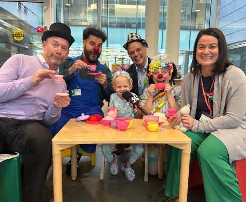 Some adults playing with a kid in a playroom