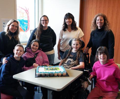 Holland Bloorview mothers Jenny, Jessica, Melissa and Allyson stand behind their daughters and inpatient clients Hannah, XX, Finnley and Scarlett who met during their time at the hospital. 