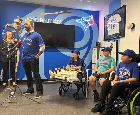 A group of people in an indoor setting, with some Blue Jays logos