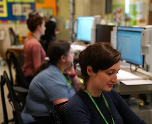 A nurse works alongside colleagues at a nursing station in the inpatient unit at Holland Bloorview Kids Rehabilitation Hospital.