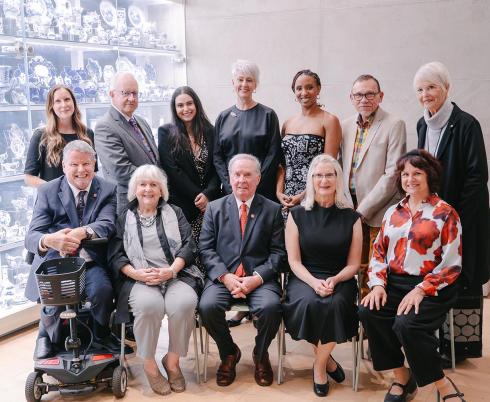 Dr. Peter Rumney (second from left, top row) and Zoe Garzouzi, chair of Holland Bloorview’s Youth Advisory Council (third from left, top row), pose with the 2026 Empowered Kids Ontario Tribute Award winners. Also pictured are EKO leadership and the evening’s host, the Honourable Jim Munson.