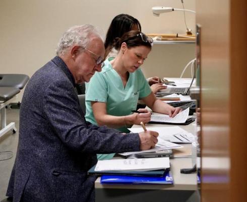 Dr. Peter Rumney reviewing charts with the Brain Injury Rehab team at Holland Bloorview, 2025.